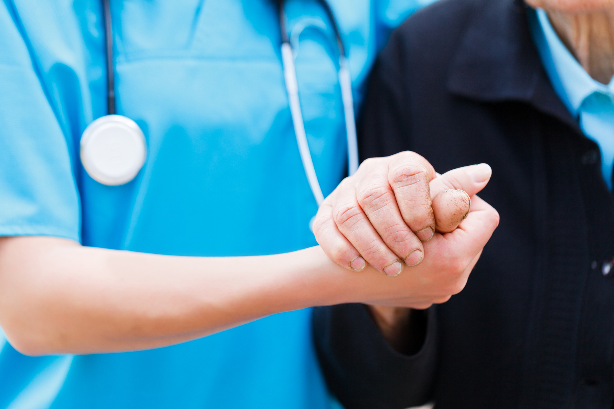 Nurse hodling elderly persons hand